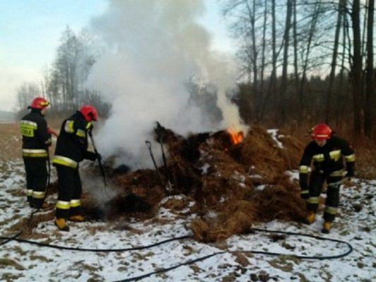 strażacy gaszą palące się siano